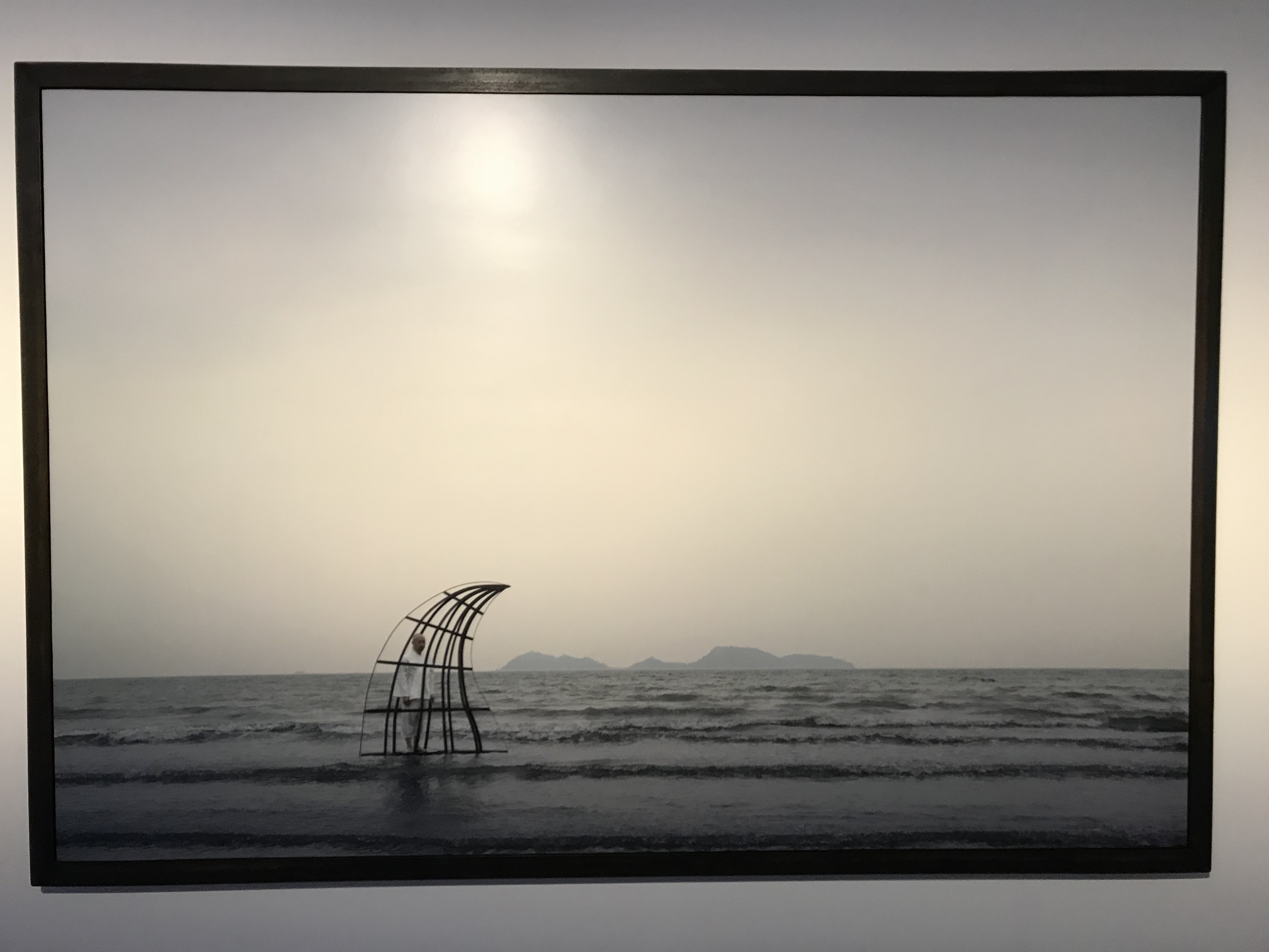 In the photograph “Confessional”, a man stands in the cage shaped as shark fin to rethink his crimes.
